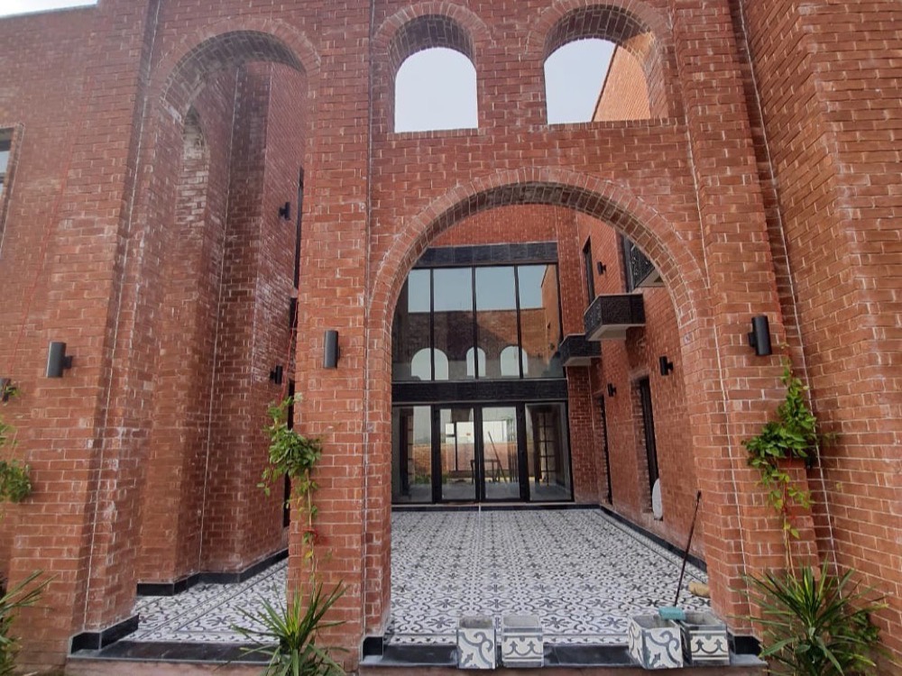 Brick villa entrance over a patterned cement tile courtyard